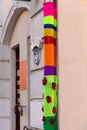 A downpipe wrapped in a colorful bright knitted fabric