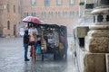 Market trader tries to protect his goods from the downpour