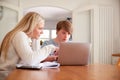 Downs Syndrome Man Sitting With Home Tutor Using Laptop For Lesson At Home Royalty Free Stock Photo