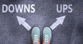 Downs and ups as different choices in life - pictured as words Downs, ups on a road to symbolize making decision and picking