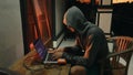 Downshifter Hacker programmer in a hood creates a new program with viruses. A novice programmer student is working on