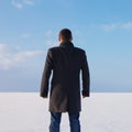 Downshifting way man standing on the shore of a frozen sea relax