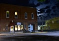 Downtown historic district of River falls Wisconsin with the moon visible between clouds above the streets