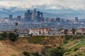 Downtown Los Angeles skyline with homes and snowcapped mountains