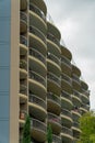 Downtown round apartment building balconies in late afternoon shade with gray cloudy skies in early morning sunrise