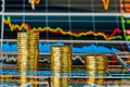 Downtrend financial chart and stacks of golden coins