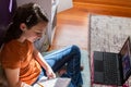 Downward view of teen writing in notepad at home in bedroom