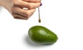 Dowser with hand-held pendulum checks the usefulness of avocado fruit.