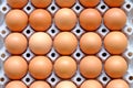 A dozen brown eggs in a carton on a wooden table Royalty Free Stock Photo