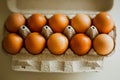 A dozen chicken eggs are in a cardboard box from the store, which is on the table. Healthy food for breakfast. Protein Royalty Free Stock Photo