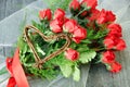 Dozen red roses, with green, red ribbon, wicker heart Royalty Free Stock Photo