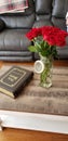 A dozen red Valentine roses sitting on coffee table beside family Bible in Kentucky farmhouse Royalty Free Stock Photo