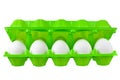 Dozen white eggs in open green plastic package on white background isolated close up front view