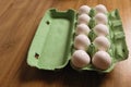 Dozen white fresh chicken eggs in the green cardboard egg tray on wooden table background. Fresh organic eggs in Royalty Free Stock Photo