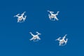 Dozens of drones swarm in the blue sky. Quadcopters drones with digital camera in the air over city. New technology in the aero