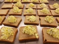 Dozens of egg salad sandwiches on metal table at the soup kitchen, feeding the hungry
