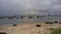 Dozens of fishing boats on a shore of da nang, vietnam. Grey sky, city in the background.