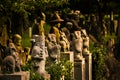 Dozens of minature buddha statues in a temples park in Kyoto. Warm sunset lighting and close up view