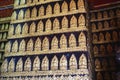 Dozens of tiny golden Buddha medallions line the walls of a temple near Luang Prabang, Laos