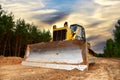 Dozer during clearing forest for construction new road. Bulldozer at forestry work on sunset background. Earth-moving equipment at Royalty Free Stock Photo