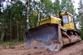 Dozer during clearing forest for construction new road . Yellow Bulldozer at forestry work Earth-moving equipment at road work, Royalty Free Stock Photo