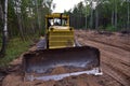Dozer during clearing forest for construction new road . Yellow Bulldozer at forestry work Earth-moving equipment at road work, Royalty Free Stock Photo