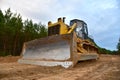 Dozer during clearing forest for construction new road . Yellow Bulldozer at forestry work Earth-moving equipment at road work, Royalty Free Stock Photo