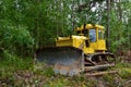 Dozer during clearing forest for construction new road . Yellow Bulldozer at forestry work Earth-moving equipment at road work, Royalty Free Stock Photo