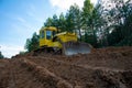 Dozer during clearing forest for construction new road . Yellow Bulldozer at forestry work Earth-moving equipment at road work, Royalty Free Stock Photo