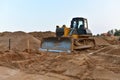 Dozer on earthmoving at construction site. Bulldozer on road work. Construction machinery and equipment on groundwork Royalty Free Stock Photo