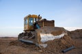 Dozer at open pit mining on sunseet background. Bulldozer for land clearing, grading, pool excavation, utility trenching and