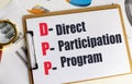 DPP acronym written as direct participation program on clipboard with charts and magnifying glass Royalty Free Stock Photo