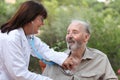 Dr with stethoscope checking senior patient.