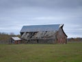 Drab Abandoned Dilapidated Farm Barn and Shed with clouds Royalty Free Stock Photo