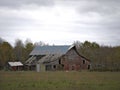 Drab Abandoned Dilapidated Farm Barn and Shed with clouds Royalty Free Stock Photo