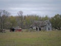 Drab Abandoned Dilapidated Farm House and Shed with clouds Royalty Free Stock Photo