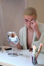 Drag queen person removing the make up and wearing bathrobe.