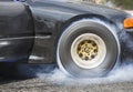 Drag racing car burns rubber off its tires Royalty Free Stock Photo