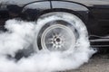 Drag racing car burns rubber off its tires Royalty Free Stock Photo