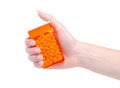 Dragee in orange container in hand Royalty Free Stock Photo