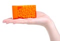 Dragee in orange container in hand Royalty Free Stock Photo