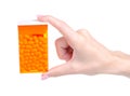 Dragee in orange container in hand Royalty Free Stock Photo