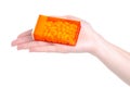 Dragee in orange container in hand Royalty Free Stock Photo