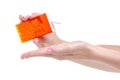 Dragee in orange container in hand Royalty Free Stock Photo