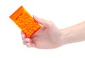 Dragee in orange container in hand Royalty Free Stock Photo