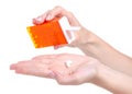 Dragee in orange container in hand Royalty Free Stock Photo