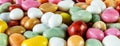 Pills candy multicolored pebbles background close up