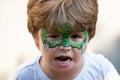 Dragon body art. Child with a mask on his face. Carnival. Favorite hero for a childrens party. Green face and fangs. A Royalty Free Stock Photo