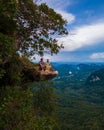 Dragon Crest mountain Krabi Thailand, a Young traveler sits on a rock that overhangs the abyss, with a beautiful Royalty Free Stock Photo