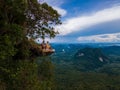 Dragon Crest mountain Krabi Thailand, a Young traveler sits on a rock that overhangs the abyss, with a beautiful